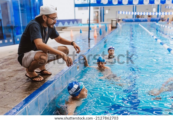 Latin
swimming man trainer talking some advices to teenagers swimmers
students at the pool in Mexico Latin
America
