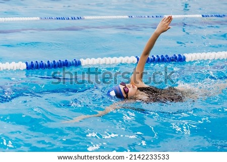 latin teen girl swimmer athlete wearing cap and goggles in a swimming training holding On Starting Block In the Pool in Mexico Latin America