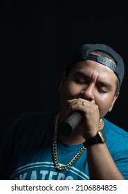 latin urban artist, rapper singing with passion, using a microphone