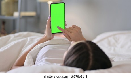 Latin Woman in Bed Using Smartphone with Green Screen, Chroma Screen  - Powered by Shutterstock