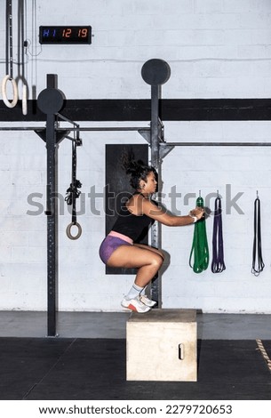 latin Woman doing box jumps at crossfire gym