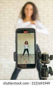 Latin woman influencer created her dancing video by smartphone camera. To share video to social media application. - Shutterstock ID 2121691949