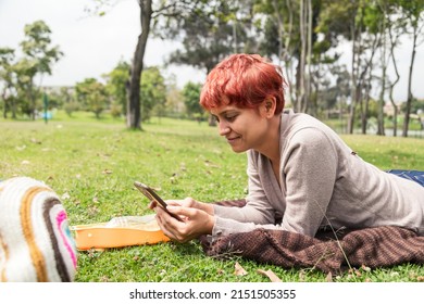 Latin Woman Looking At The Cell Phone In The Park