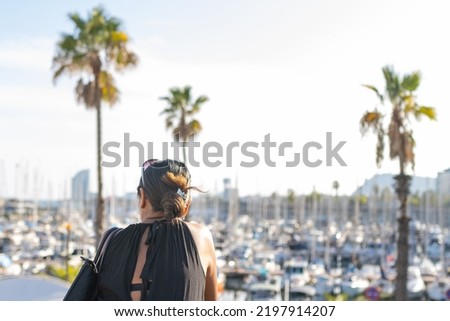 Latin woman on her back on vacation in the Olympic port of Barcelona (Spain), travel concept.