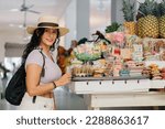 Latin woman on vacation in a market with typical sweets, stock image with copy space.