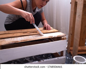 Latin Woman Painting Wooden Boxes with White Paint on Black Bags in the Morning