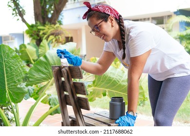 Latin Woman Painting Wooden Chair In Garden House