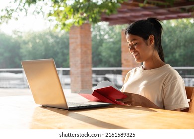 Latin Woman Reading A Red Book. Young College Girl Studying With A Laptop. Copyspace.