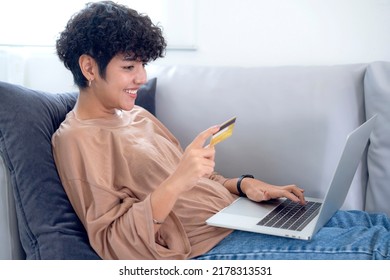 Latin Woman Shopping Online By Application In Computer Note Book And Pay Monry Online By Credit Card On Sofa