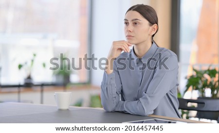 Latin Woman Sitting in Office and Thinking 