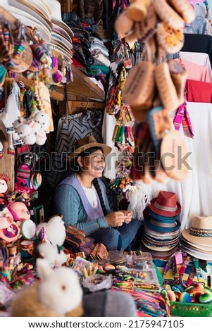 Latin woman smiling at her job in a typical souvenir store in South America