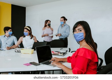 Latin Woman And Teamwork Working In Business Office While Wearing Face Mask For Social Distancing In New Normal Situation Preventing The Infection Of Corona Virus Or Covid-19 Mexican People