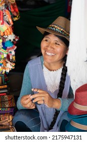 Latin Woman Weaving With Wool In A Handicraft Store Wearing Hat And Braids
