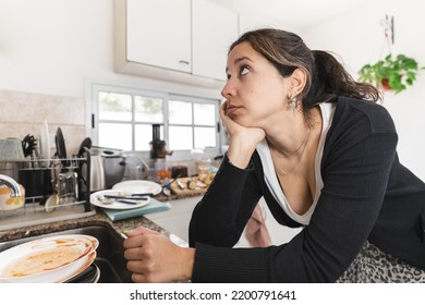 Latin Woman Worried About Her Messy Kitchen. Close Up To Her Face