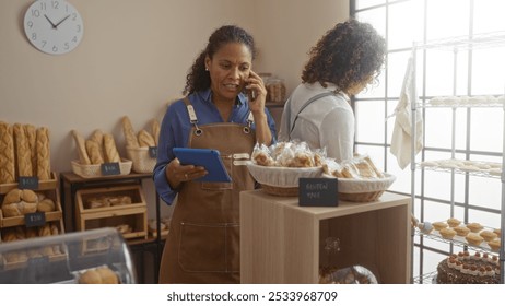 Latin women working in bakery shop with pastries and bread in the background - Powered by Shutterstock