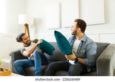 Latin Young Gay Man Flirting With His Boyfriend While Having A Fun Pillow Fight At Home During A Romantic Date