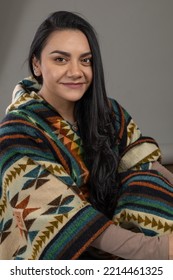 Latin Young Woman With Black Hair Smiling Looking At Camera, Natural Beauty And Fashion With Poncho From Latin American Culture In Studio
