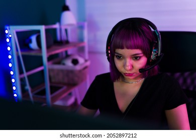 Latin Young Woman And Gamer With A Headset Playing An Online Video Game On Her Computer 