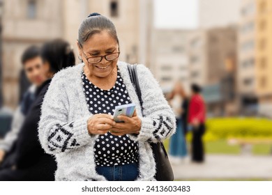 Latina adult woman, with a happy expression, in the city using h - Powered by Shutterstock