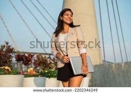 Latina businesswoman walks happily to work with a laptop on the street ストックフォト © 