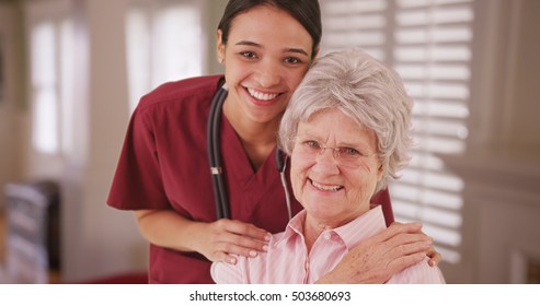 Latina Caretaker With Senior Woman Smiling