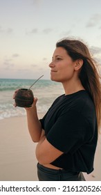 latina girl drinking Argentinian traditional drink called mate in the beach