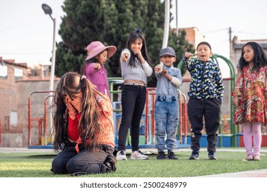 latina girl gets teased and laughed at by her schoolmates in a park in bolivia - abuse concept - Powered by Shutterstock