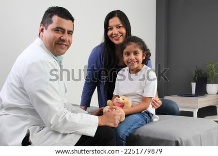 Latina mother cares for and accompanies her curly little daughter at the dark-haired pediatrician specialist doctor's office to prevent abuse and harassment at her medical checkup
