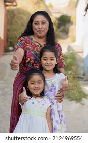 Latina Mother With Her Two Happy Daughters Outside Her House In Rural Area - Hispanic Women With Thumbs Up