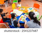 Latina teacher guiding young boys and girls in a teamwork activity in a primary or preschool setting