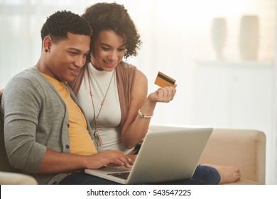 Latin-American couple shopping online at home