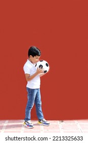 Latino 8-year-old Boy Plays With A Soccer Ball Very Excited That He Is Going To See The World Cup And Wants To See His Team Win
