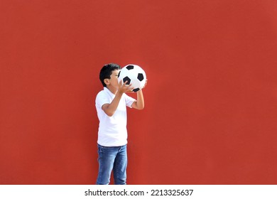 Latino 8-year-old Boy Plays With A Soccer Ball Very Excited That He Is Going To See The World Cup And Wants To See His Team Win
