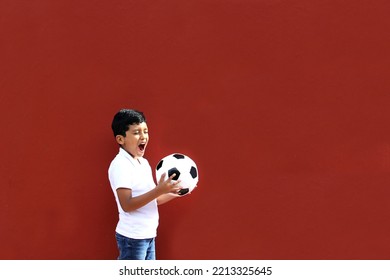 Latino 8-year-old Boy Plays With A Soccer Ball Very Excited That He Is Going To See The World Cup And Wants To See His Team Win
