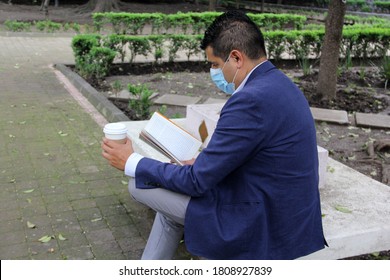 Latino adult man with protection mask, coffee and reading book in the park, new normal covid-19 - Shutterstock ID 1808927839