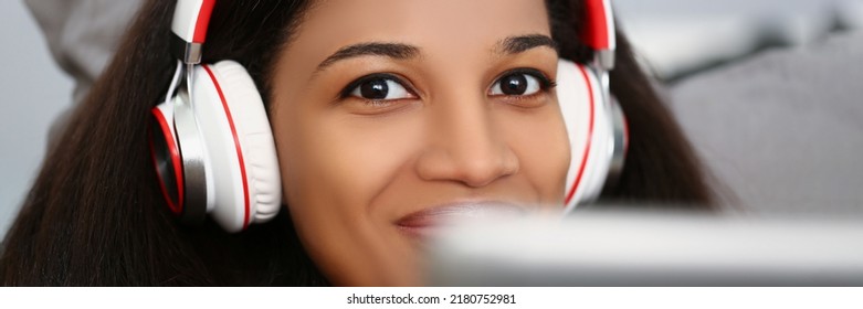 Latino American Young Woman Wear Headset And Watch Movie Or Take Online Class