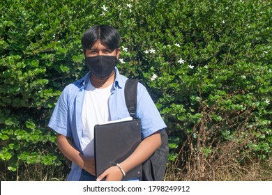 Latino College Boy With Face Mask Holding Books