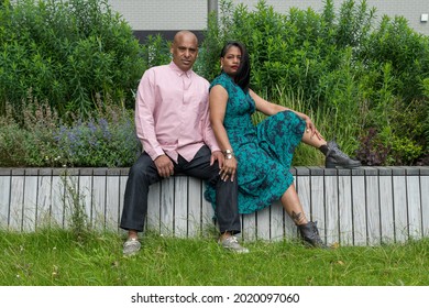 Latino Couple He With A Pink Shirt And She With A Green Dress And Leather Boots