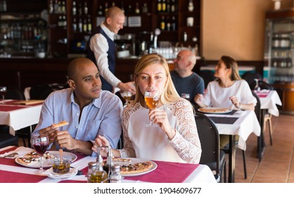 Latino Couple In Love Eating Pizza At Cozy Restaurant