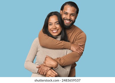 Latino couple in love embracing warmly in studio - Powered by Shutterstock