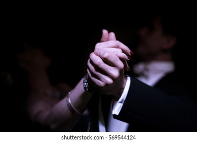 Latino dancers hands in ballroom  on black background