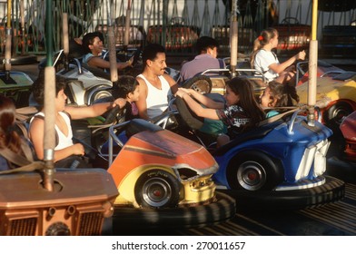 Latino Family On The Bumper Cars At Santa Monica Pier, California