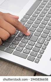 Latino hands using a computer. Brown fingers typing a laptop. Laptop keyboard being used by Latin hands. Vertical imagen