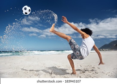 Latino Hispanic man doing bicycle kick on beach with soccer ball
