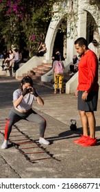 Latino Man Explaining Exercises To His Fitness Class Student.