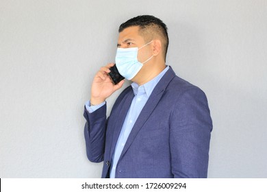 Latino Man With Face Mask Talking On Cell Phone
