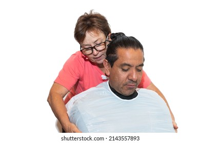 Latino man getting ready for a haircut with an older woman and professional stylist