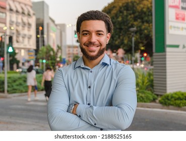 Latino man looking at camera and smiling on the street - Powered by Shutterstock