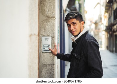 Latino Man Ringing A Building Doorbell