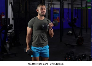 Latino Man With Sportswear Doing Biceps Exercises With Two Dumbbells In A Gym